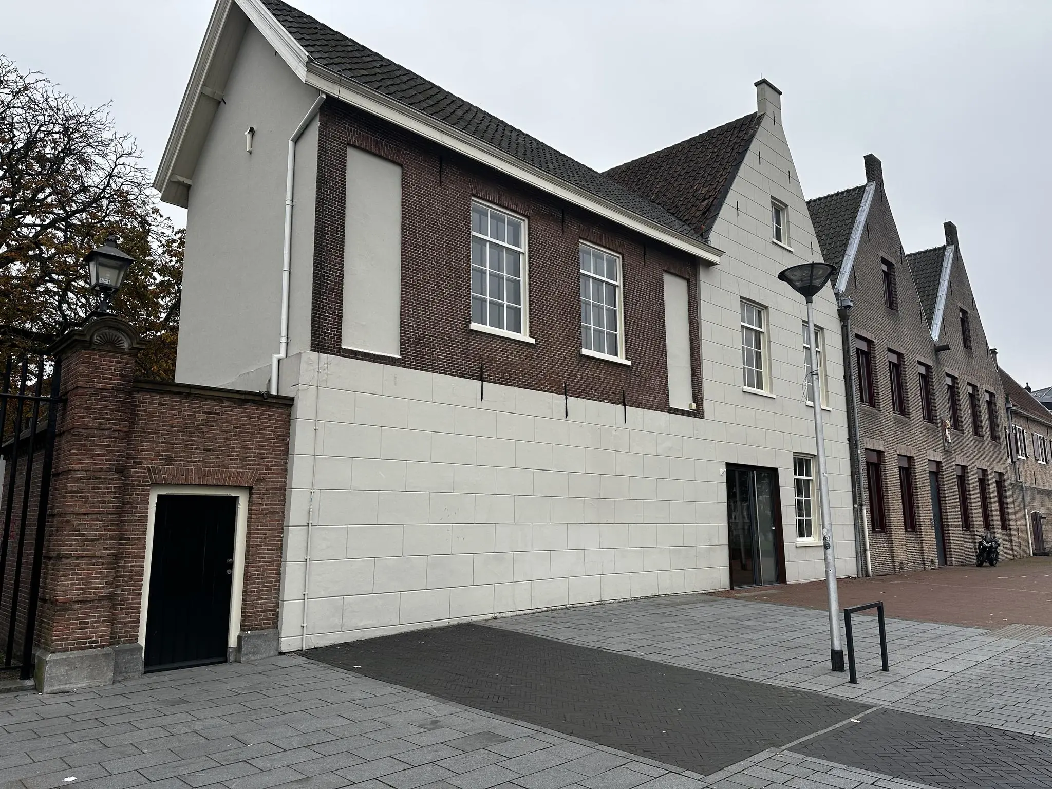 Rij historische gebouwen aan het Sint-Agathaplein met bakstenen gevels en trapdaken.